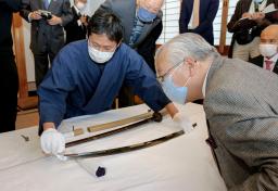 <p>　日本刀の引き渡し式で、日本財団の森祐次常務理事（右手前）に、修復過程について説明する横山智庸さん（左）＝６日午前、岡山県瀬戸内市</p>