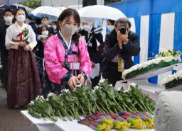<p>　慰霊碑の前に献花する参列者＝６日午前、長崎市</p>