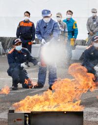 <p>　初期消火訓練を体験する岸田首相（中央）＝７日午前、横浜市</p>