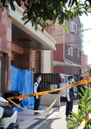 <p>　高齢男性と女性が倒れ死亡していた有料老人ホーム前に立つ警察官ら＝１７日午前、大阪市</p>