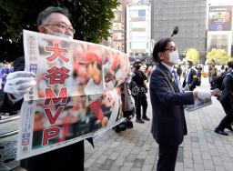 <p>　米大リーグ、エンゼルスの大谷翔平選手がア・リーグＭＶＰに選出され、ＪＲ新橋駅前で特別号外を配る岩手日報社の東根千万億社長（右）＝１９日午後</p>