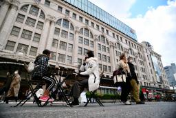 <p>　南海電鉄難波駅前を歩行者天国にする社会実験が行われ、設置された椅子に座る人たち＝２３日午後、大阪市</p>