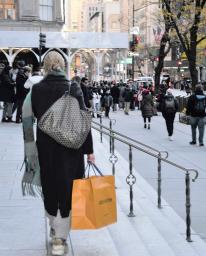 <p>　高級ブランドの買い物袋を下げた女性＝２４日、ニューヨーク（共同）</p>