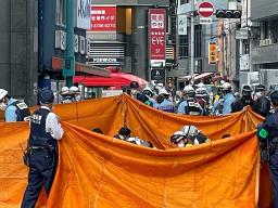 　シートで覆いビル火災負傷者を救護する消防隊員ら＝１７日午前１１時１０分、大阪市北区