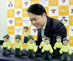 　完成した自身のフィギュアを前に笑顔を見せる演歌歌手三山ひろしさん＝１７日、高知県南国市