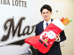 　契約更改交渉を終え、お菓子を手にするロッテ・佐々木朗＝１７日、ＺＯＺＯマリン