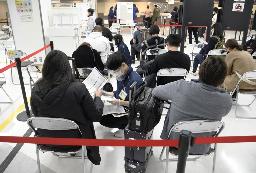 　海外から到着し、検疫のスタッフ（手前中央）から必要書類や滞在地などの確認を受ける旅客＝１日、成田空港