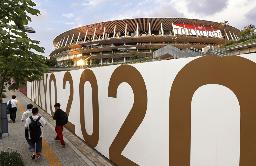 　「ＴＯＫＹＯ２０２０」の装飾と国立競技場＝６月、東京都新宿区