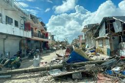 　台風２２号の影響で倒れた電柱と損壊した家屋＝１８日、フィリピン・セブ島（フィリピン副大統領府提供、ＡＰ＝共同）