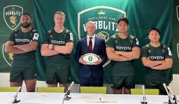 　記者会見でポーズをとる新加入のデュトイ（左から２人目）、姫野（右から２人目）らトヨタの選手とクロン・ヘッドコーチ（中央）＝２２日、愛知県豊田市
