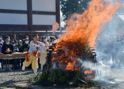 　成田山新勝寺の「納め札お焚き上げ」で、お札を「智慧の火炎」に投げ入れる山伏姿の僧侶＝２８日午前、千葉県成田市