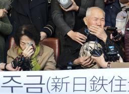 　韓国の元徴用工訴訟で韓国最高裁が新日鉄住金（現日本製鉄）の上告を棄却し、記者団の取材に応じる原告の李春植さん（右）＝２０１８年１０月、ソウル（共同）