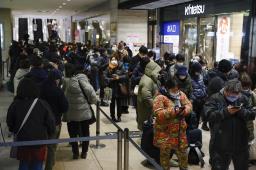 　新年の初売りが始まる近鉄百貨店本店前で開店を待つマスク姿の人たち＝２日午前、大阪市