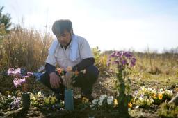 　２０１６年に木村汐凪さんの遺骨の一部が見つかった場所の近くで、手向けた花を見つめる父紀夫さん＝２０２０年１２月、福島県大熊町