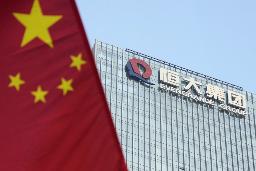 　中国恒大集団の本社が入るビル。左はビル前の通りに掲げられた中国国旗＝２０２１年９月、中国広東省深セン市（共同）