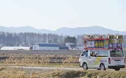 　大型スピーカーを取り付け、広大な畑の中を走る選挙カー＝２０１４年１２月、北海道北見市（候補者名などを画像加工をしています）