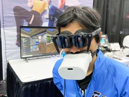 　仮想現実（ＶＲ）対応端末を装着して来場者に説明するパナソニックの子会社シフトールの岩佐琢磨ＣＥＯ＝３日、米ラスベガス（共同）