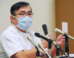 　記者会見で、昨年１２月に出産した女性の健康保険証などのコピーが入った封筒を手にする慈恵病院の蓮田健院長＝４日午後、熊本市