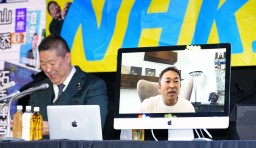 　記者会見でＮＨＫ党の立花党首（左）とオンラインで話す比例代表候補者のガーシー氏＝１０日午後８時９分、東京都港区