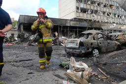 　砲撃を受けた建物の付近を歩く消防士＝１４日、ウクライナ・ビンニツァ（ＡＰ＝共同）