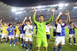 　スペインに逆転勝ちで決勝トーナメント進出を決め、スタンドの観客にあいさつするＧＫ権田ら日本イレブン＝ドーハ（共同）