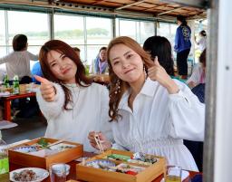 　佐賀市と福岡県大川市の間を流れる筑後川で運航が始まった観光遊覧船の船内でポーズをとる乗客＝１日