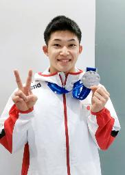 　成田空港で銀メダルを手にポーズをとる男子高飛び込みの玉井陸斗＝９日