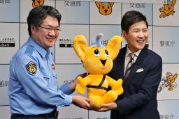 　交通安全広報大使の委嘱式で、「ピーポくん」のぬいぐるみを受け取るタレントの関根勤さん（右）＝２７日午前、警視庁