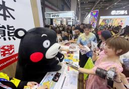　２８日、中国上海市のイベントで来場者に名刺を渡すくまモン（共同）