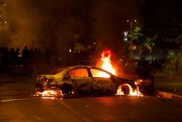 　２９日、フランス・パリ郊外ナンテールで、警察に抗議する人々と警察官らの衝突で燃やされた車（ロイター＝共同）