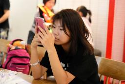　飲食店でスマートフォンを操作する未成年＝４日、北京（共同）