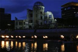 　被爆から７８年の「原爆の日」を前に、原爆ドーム前の元安川でともされたかがり火＝５日夕、広島市