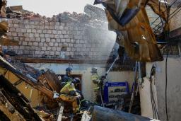 　６日、ウクライナ東部ドネツク州で砲撃を受けたとされる大学の建物で作業に当たる消防士（ロイター＝共同）