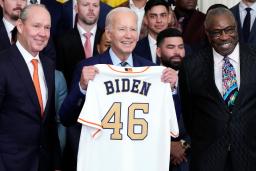 　米大リーグのアストロズから贈られた背番号「４６」のユニホームを手にするバイデン大統領＝７日、ホワイトハウス（ＡＰ＝共同）