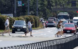 　東京都内で景色が揺らいで見えるかげろうの中を歩く人ら＝７月