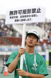 　全国高校総合体育大会の陸上会場で「無許可撮影禁止」を呼びかけるスタッフ＝４日、札幌厚別公園競技場