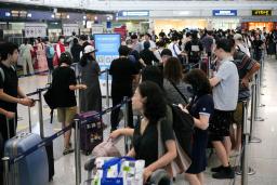 　北京首都国際空港で日本行きの便にチェックインするため、列に並ぶ中国人の個人旅行客ら＝１０日（共同）