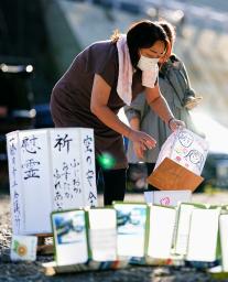 　日航ジャンボ機墜落事故から３８年を控え、神流川の河原で灯籠を準備する女性＝１１日午後、群馬県上野村