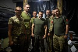 　１４日、ウクライナ東部ドネツク州の軍旅団司令部で、兵士と記念撮影するゼレンスキー大統領（中央）（ウクライナ大統領府提供、ＡＰ＝共同）