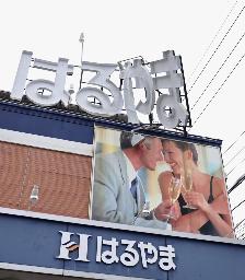 　突風で曲がった店舗の看板＝１５日、静岡市