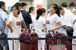 　搭乗手続きで列に並ぶテコンドーの北朝鮮代表団＝１８日、北京首都国際空港（共同）