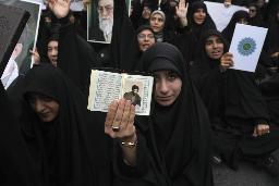 　イスラム教の聖典コーランを掲げ、イラン・テヘランのスウェーデン大使館前で抗議する人たち＝７月（ＡＰ＝共同）