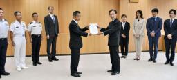 　防衛省幹部（手前左）にハラスメント防止に向けた提言を手渡す有識者会議の座長ら＝１８日午前、防衛省