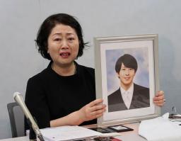 　高島晨伍さんの遺影を手に、記者会見する母親の淳子さん＝１８日午後、大阪市