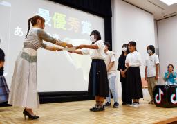 　「不登校生動画選手権」で最優秀賞を受賞し、審査委員長の中川翔子さん（左）から賞状を受け取る「学びスペースあうるの森」の子どもたち＝１８日午後、東京都内