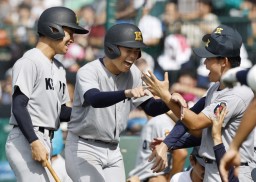 　沖縄尚学―慶応　６回表、生還しベンチで迎えられる慶応・加藤（中央）＝甲子園