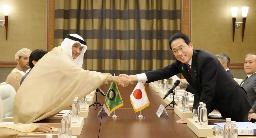　７月、湾岸協力会議（ＧＣＣ）のブダイウィ事務局長（左）と握手する岸田首相＝ジッダ（共同）