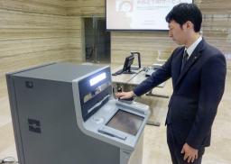 　ＡＴＭで手のひらの静脈認証をする高知信用金庫の職員＝２８日、高知市