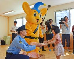 　警視庁練馬署の警察官からプレゼントを渡される「どんぐり山保育園」の園児＝３０日午前、東京都練馬区