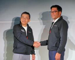 　記者会見でスペースＸ幹部（右）と握手するＫＤＤＩの高橋誠社長＝３０日午前、東京都千代田区
